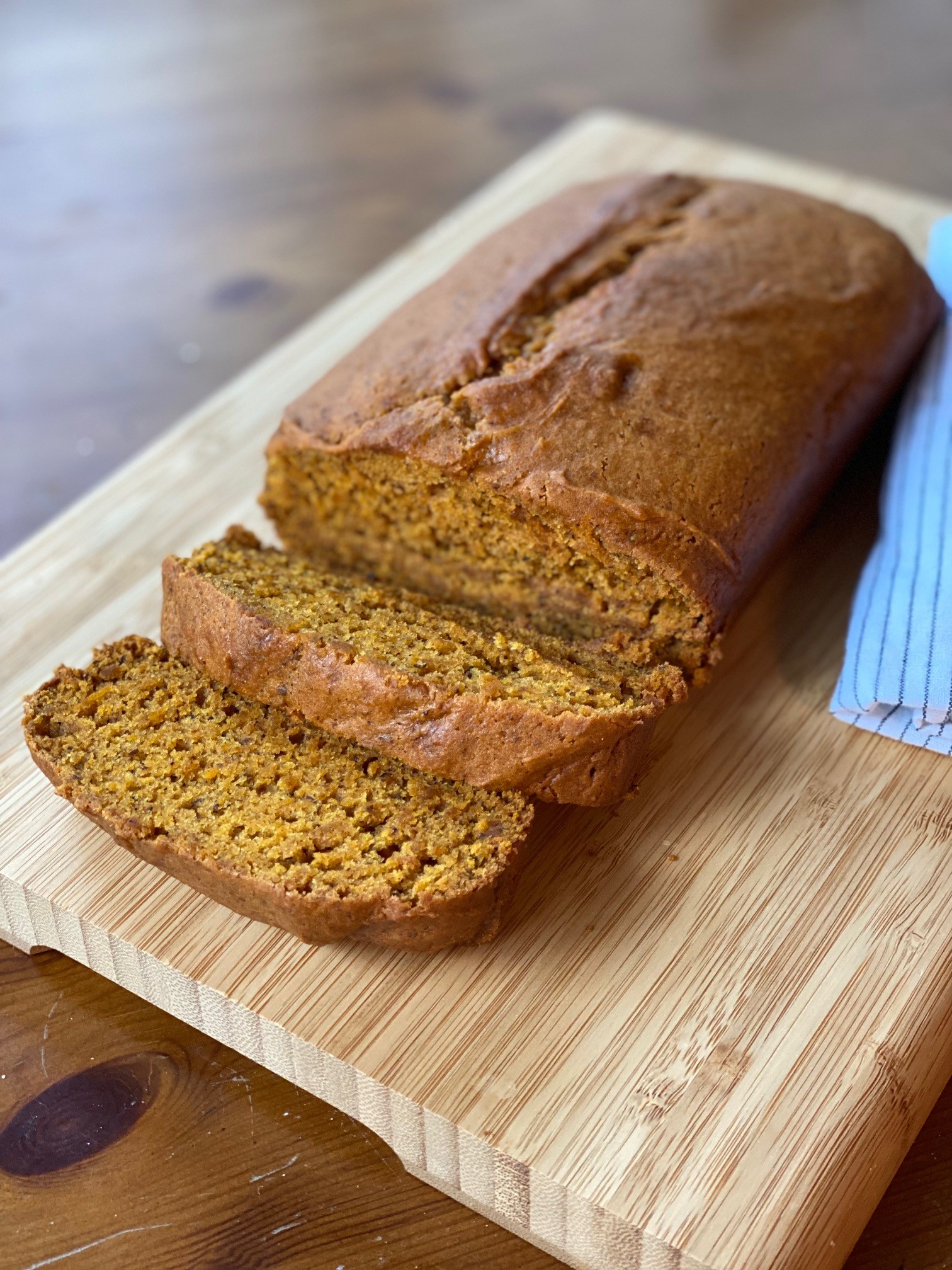 a loaf of vegan pumpkin bread on a cutting board