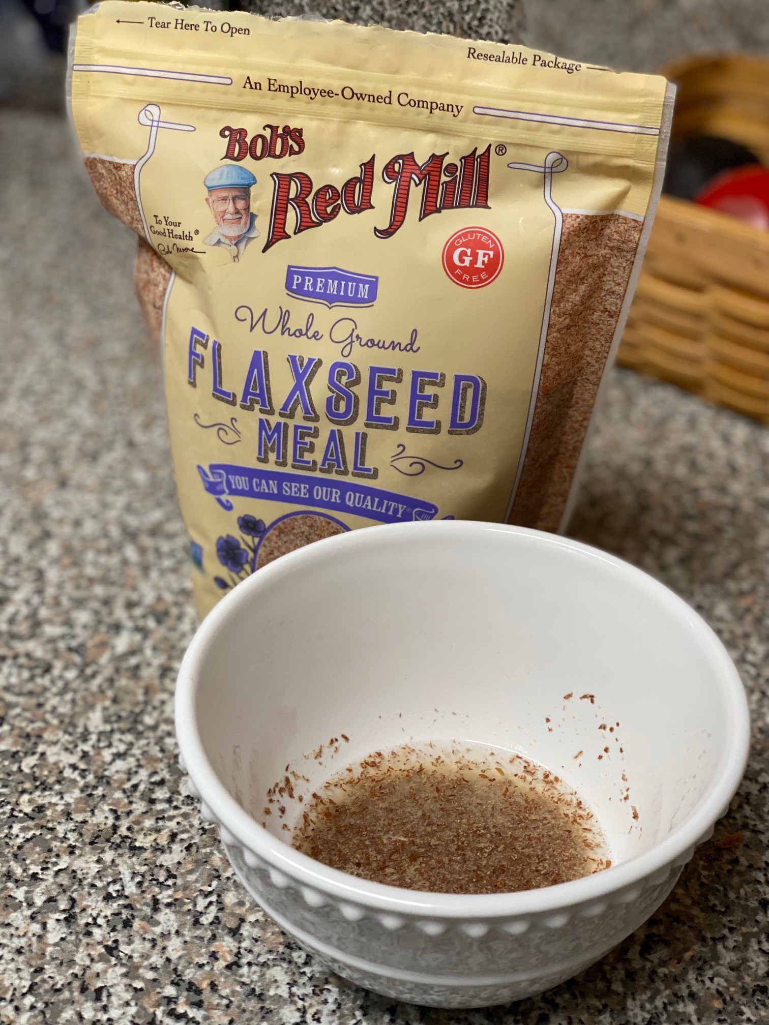 A bag of flaxseed meal and a bowl of flaxseed and water mixture