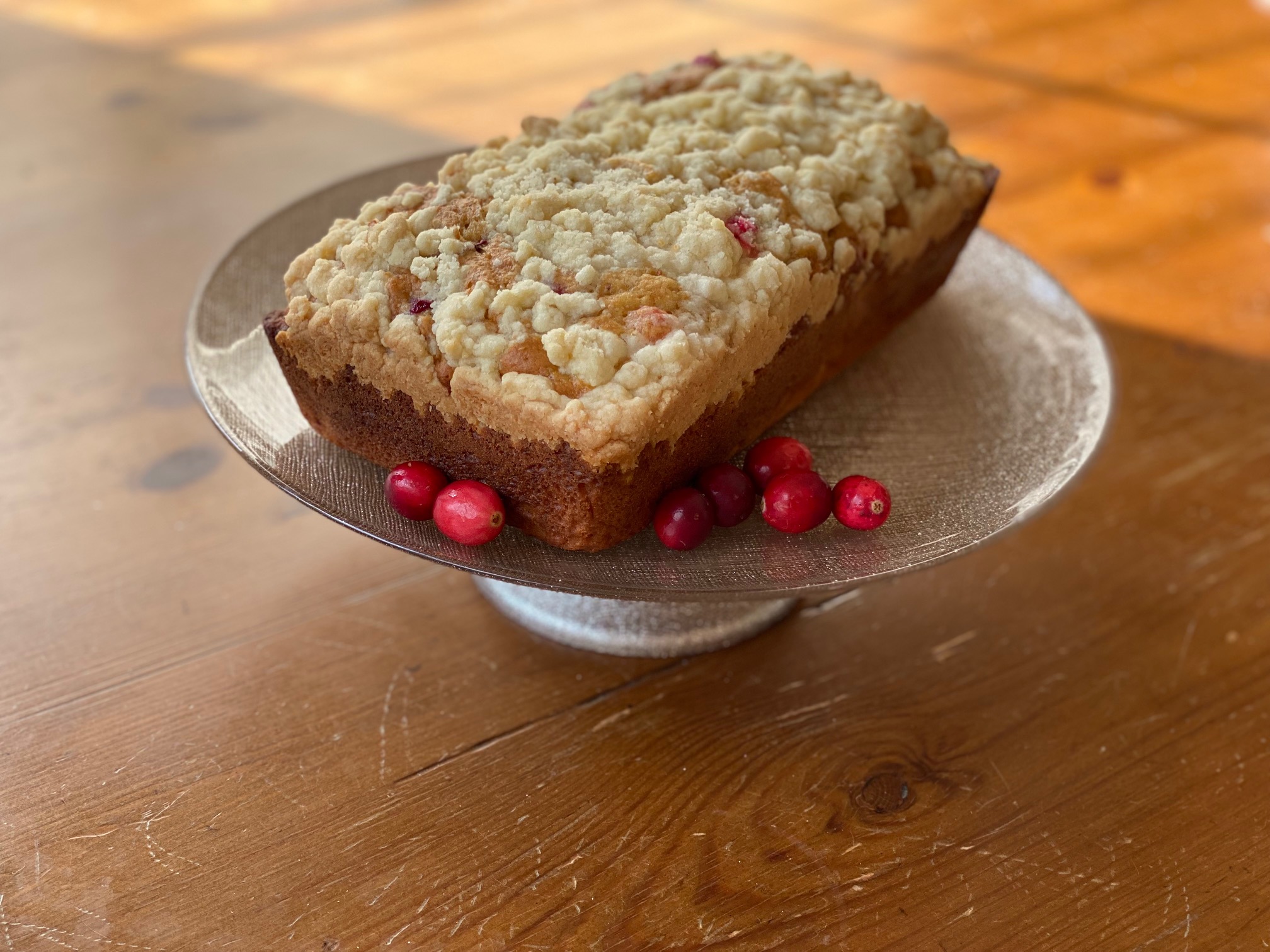 A loaf of cranberry orange bread on a pedestal