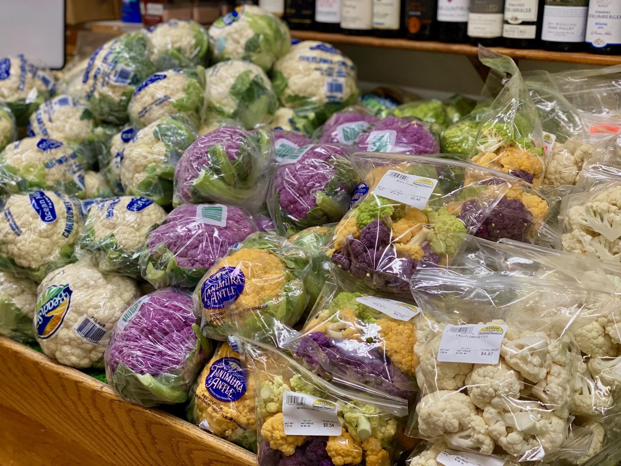 Bags of multi-colored cauliflower on a grocery store shelf